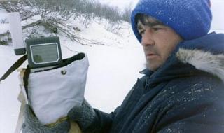 Technicien dehors pendant l’hiver qui tient un GPS à main