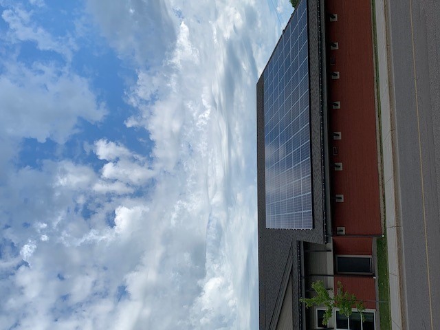Photo de la façade de l’édifice multifonctionnel dont le toit est doté de panneaux solaires.