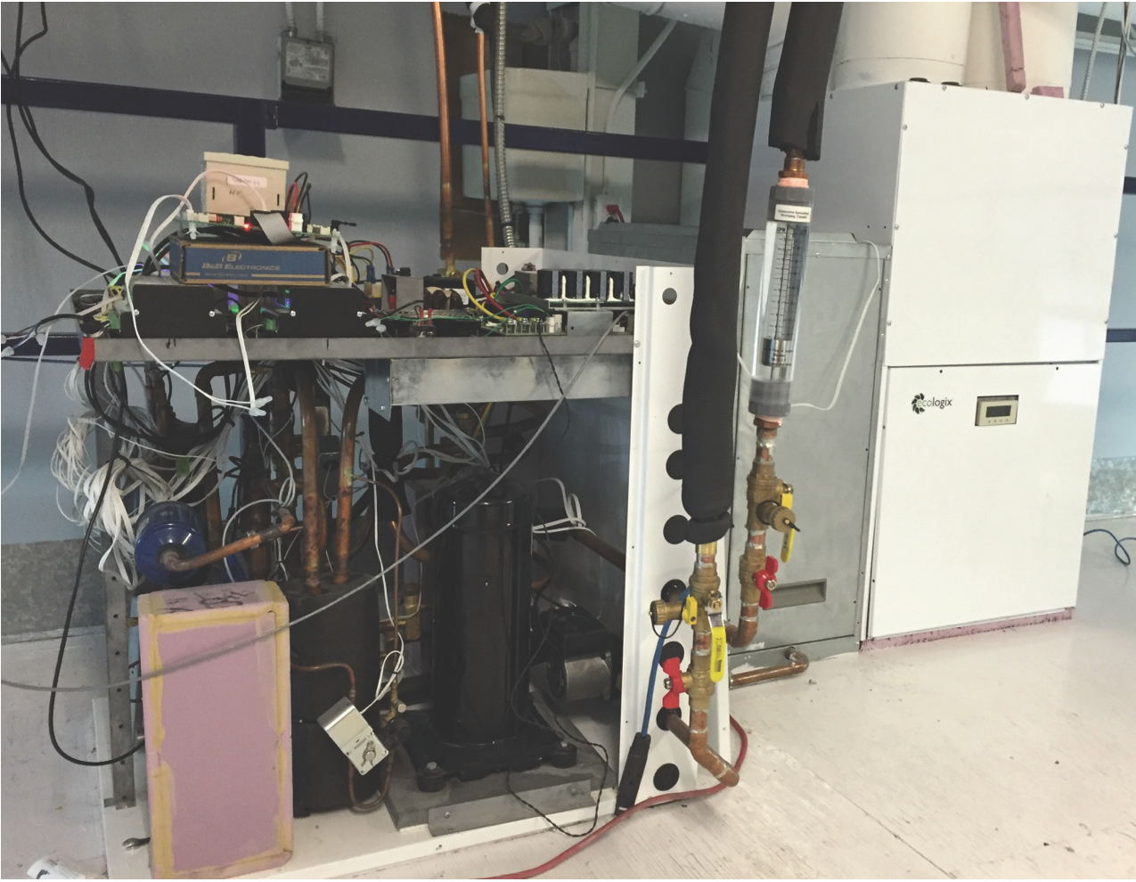La photo présente l’intérieur du prototype de module de thermopompe intégrée de l’entreprise Ecologix raccordé à divers instruments à des fins d’essais en laboratoire et en arrière-plan, son appa