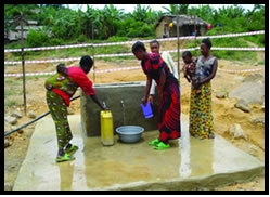 Femmes et d'enfants à une fontaine d'eau avec des récipients d'eau