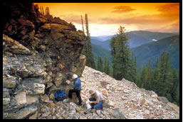 Trois géologues sur le flanc d'une montagne qui recueillent des échantillons de roches