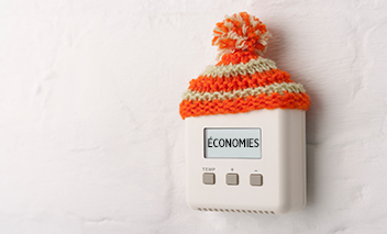Un thermostat portant un bonnet en laine indique « économies ».