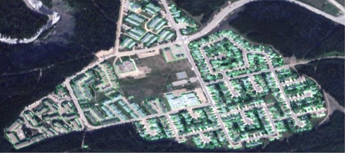 Vue aérienne des bâtiments d’une collectivité suburbaine entourée de forêts