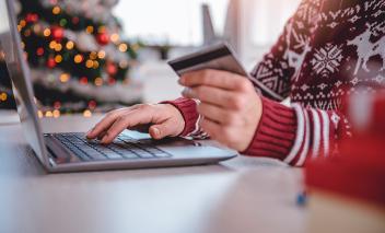 Personne magasinant en ligne et sur le point d’effectuer un achat avec une carte de crédit.